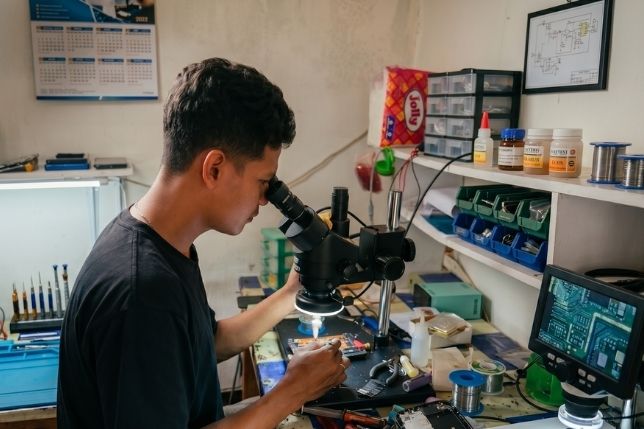 Teknisi JuandTechno sedang memeriksa handphone